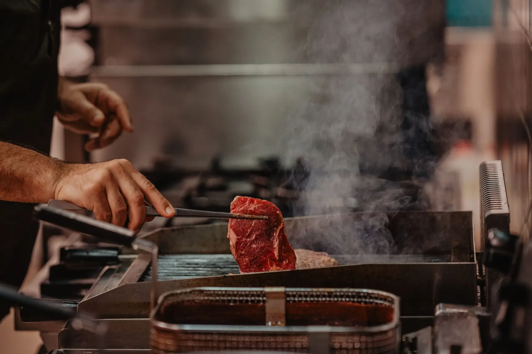 Een stuk vlees gaat op de hete grill